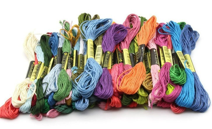 Colorful cross stitch embroidery threads in various shades, woven cotton threads for DIY cross-stitch projects.